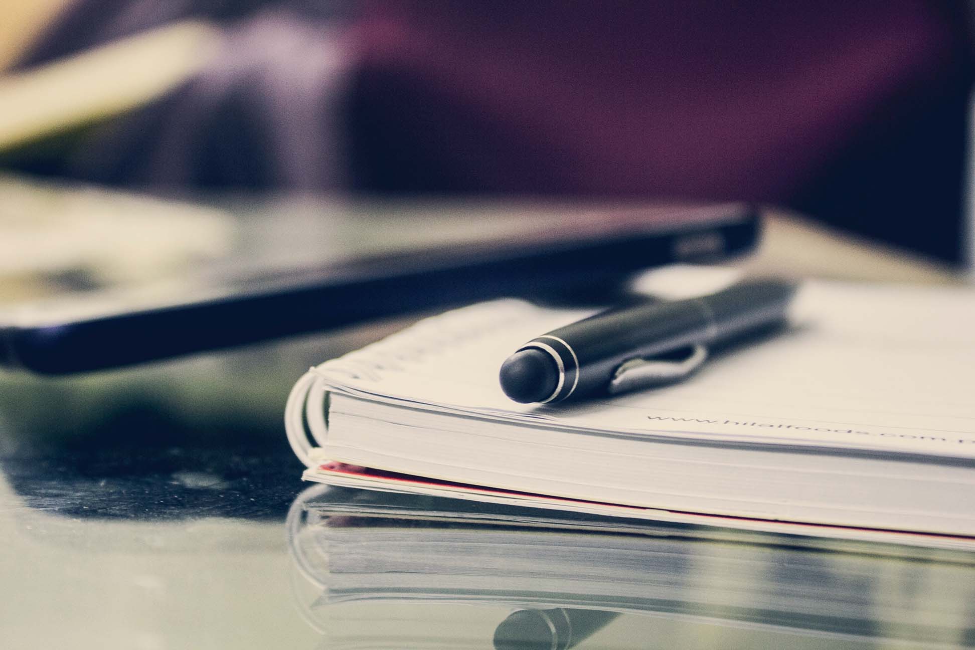 Image of a notepad with a pen on top