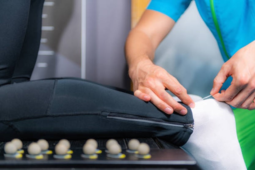 A photograph of hand examining a foot with a white sock